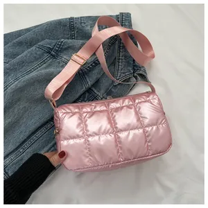 Vue détaillée du sac à bandoulière matelassé rose avec finition brillante et large sangle