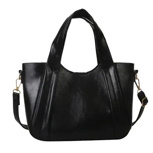 Bolso tipo cubo minimalista de cuero PU negro con herrajes dorados y correa ajustable