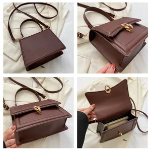 Detail view of coffee brown PU leather bag showing golden geometric lock and interior space