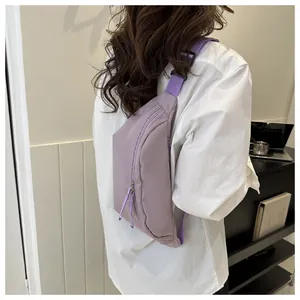 Detail of lavender nylon crossbody bag showing dual zippers and adjustable purple strap