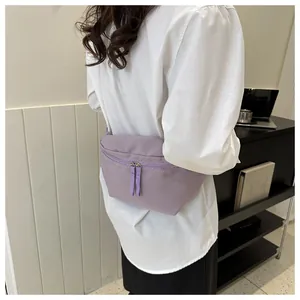 Detail of lavender nylon waist bag with double zippers and long pulls in casual setting