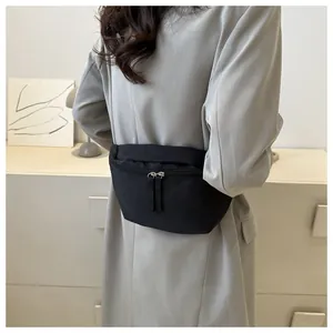 Close-up of black crossbody waist bag featuring durable nylon and premium metal zippers