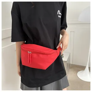 Detail of red nylon crescent waist bag featuring smooth dual silver metal zippers
