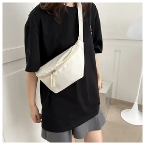 Detailed view of off-white crescent crossbody bag made of durable nylon on a model