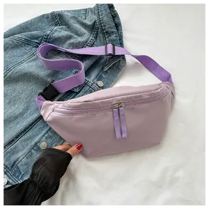 Detail of lavender nylon waist bag with silver zipper and adjustable strap on denim
