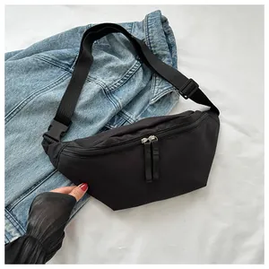 Detail of adjustable strap and plastic buckle on a black nylon crossbody sports bag
