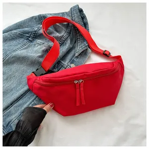 Detail of red nylon sports fanny pack with dual zippers on denim background