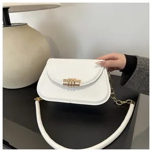 Close-up of a white minimalist PU leather shoulder bag with a gold triple-ring buckle detail