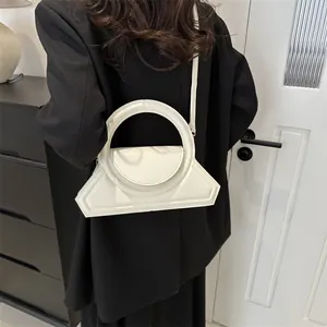 Minimalist white geometric handbag for women featuring a large round handle and shoulder strap