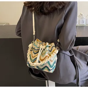 Detalle del bolso de punto bohemio con patrón de ondas coloridas y cierre de cordón ajustable