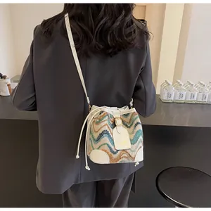 Detail of multi-color wavy knit stitching and white leather trim on women bucket bag