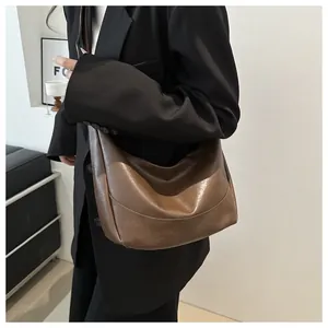 Detail view of dark brown hobo bag with vintage soft oil wax leather texture and sleek design