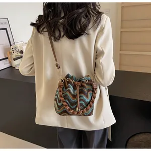 Detalle del bolso de punto bohemio con patrones de ondas coloridas y cierre de cordón