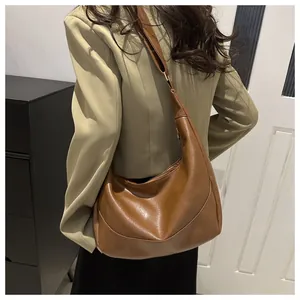 Detailed side view of the brown soft leather hobo bag with a spacious half-moon shape