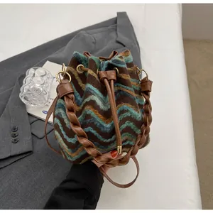Detalle del bolso tipo saco de punto bohemio con ondas verdes y cierre de cordón de cuero