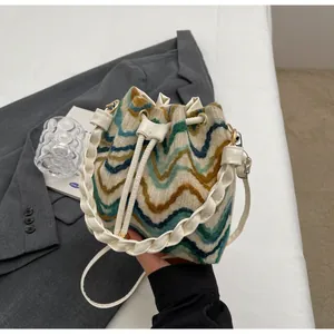 Detalle del bolso saco boho de punto con estampado de ondas y asa tejida