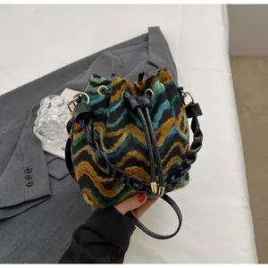 Detalle del bolso tipo cubo de punto colorido con diseño de ondas y cordón