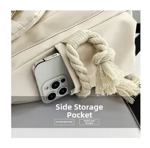 Dettaglio della tasca laterale della borsa beige con corda intrecciata e vano cellulare