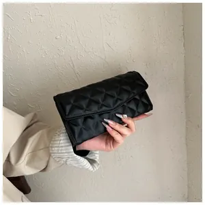 Close-up of black quilted leather long wallet for women with rhombus stitching detail