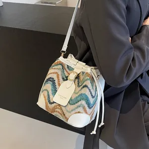 Fashionable color-block bucket bag with tweed wave pattern and white leather strap
