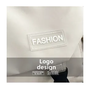 Dettaglio della borsa a tracolla beige con logo FASHION e fibbia in plastica nera