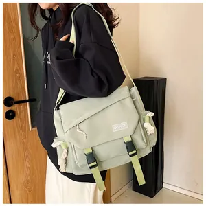 Dettaglio della borsa a tracolla in tela verde chiaro con doppie fibbie e logo fashion