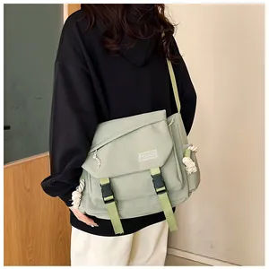 Dettaglio della borsa a tracolla in tela verde salvia con fibbie e stampa 'FASHION'