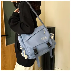 Vista laterale di una borsa a tracolla azzurra con fibbie e dettaglio in corda
