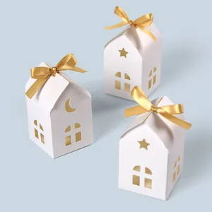 Minimalist white house-shaped gift boxes with gold ribbons and hollow window designs