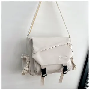 Dettaglio della borsa a tracolla in tela beige con fibbie nere e cinghia regolabile