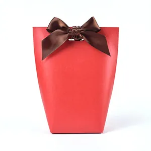 Red pearlescent paper wedding favor box with brown satin bow and cutout handle