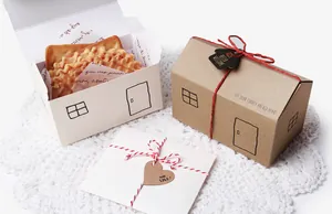 Detailed view of house-shaped gift boxes with red ribbons and heart tags on lace
