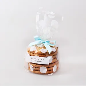 Dettaglio del nastro di raso blu lago annodato su confezione regalo per biscotti a pois