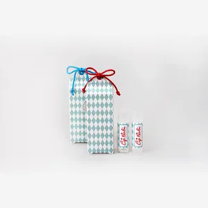 Close-up of lip balm tubes with blue diamond pattern boxes tied with cotton strings