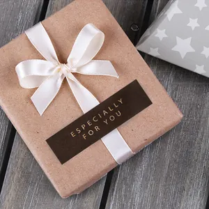 Close-up of kraft gift box with silk ribbon and gold-stamped handmade sealing sticker