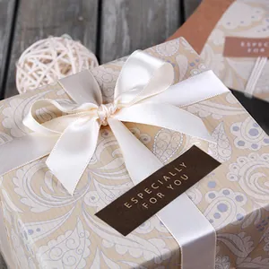 Detail of ESPECIALLY FOR YOU gold foil sticker on a gift box with a satin ribbon
