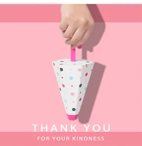 Detail of umbrella-shaped candy box with pink ribbon handle and colorful polka dots