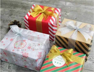 Detail of Christmas gift boxes with glitter ribbons and festive patterns on wood background