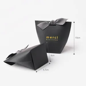 Elegant black matte gift box with gold foil merci lettering and grey ribbon bow decoration