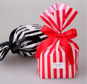 Close-up of red and black striped PP food bags with silk ribbon bows for gift packaging