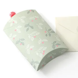 Dettaglio macro della scatola regalo a cuscino verde menta con stampe floreali e carta robusta
