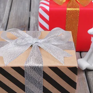 Gift box with elegant silver metallic ribbon bow on rustic kraft paper packaging