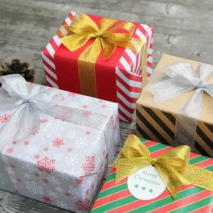 Christmas gift boxes with metallic glitter ribbons and holiday patterns on wood background