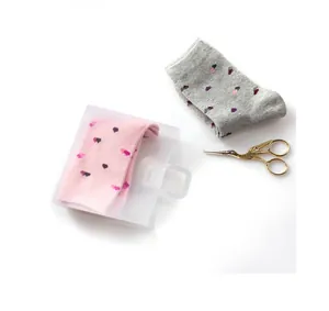 Dettaglio calzini rosa in confezione regalo e calzini grigi con motivo a pois piccoli