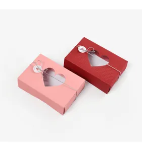 Close-up of heart-shaped window on textured gift boxes with silver elastic cords