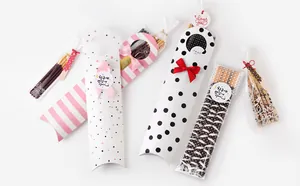 Detalle de cajas para galletas con rayas rosas, lunares y pegatinas decorativas de regalo