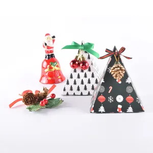 Boîtes cadeaux pyramide de Noël avec motifs festifs et rubans sur un fond blanc neutre