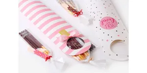 Detalle de cajas largas para galletas con cintas rosas y ventana redonda transparente