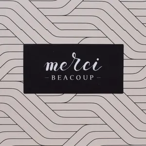 Macro shot of rectangular adhesive labels with merci beaucoup text on textured surface