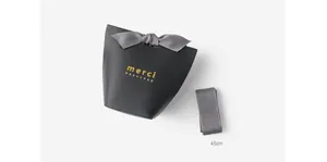 Elegant black gift box with grey satin ribbon bow and gold merci beaucoup foil stamp